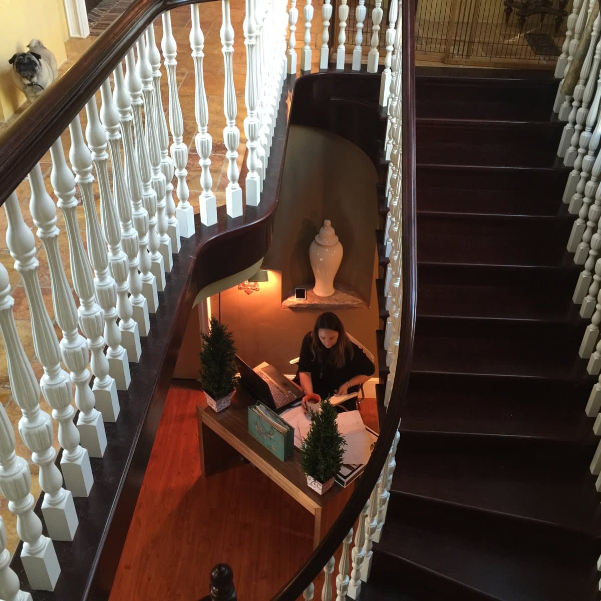 Ann McDonald working at her desk beneath a curved staircase